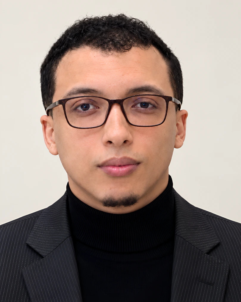Ahmed El Houdali wearing a dark pinstripe suit and black turtleneck